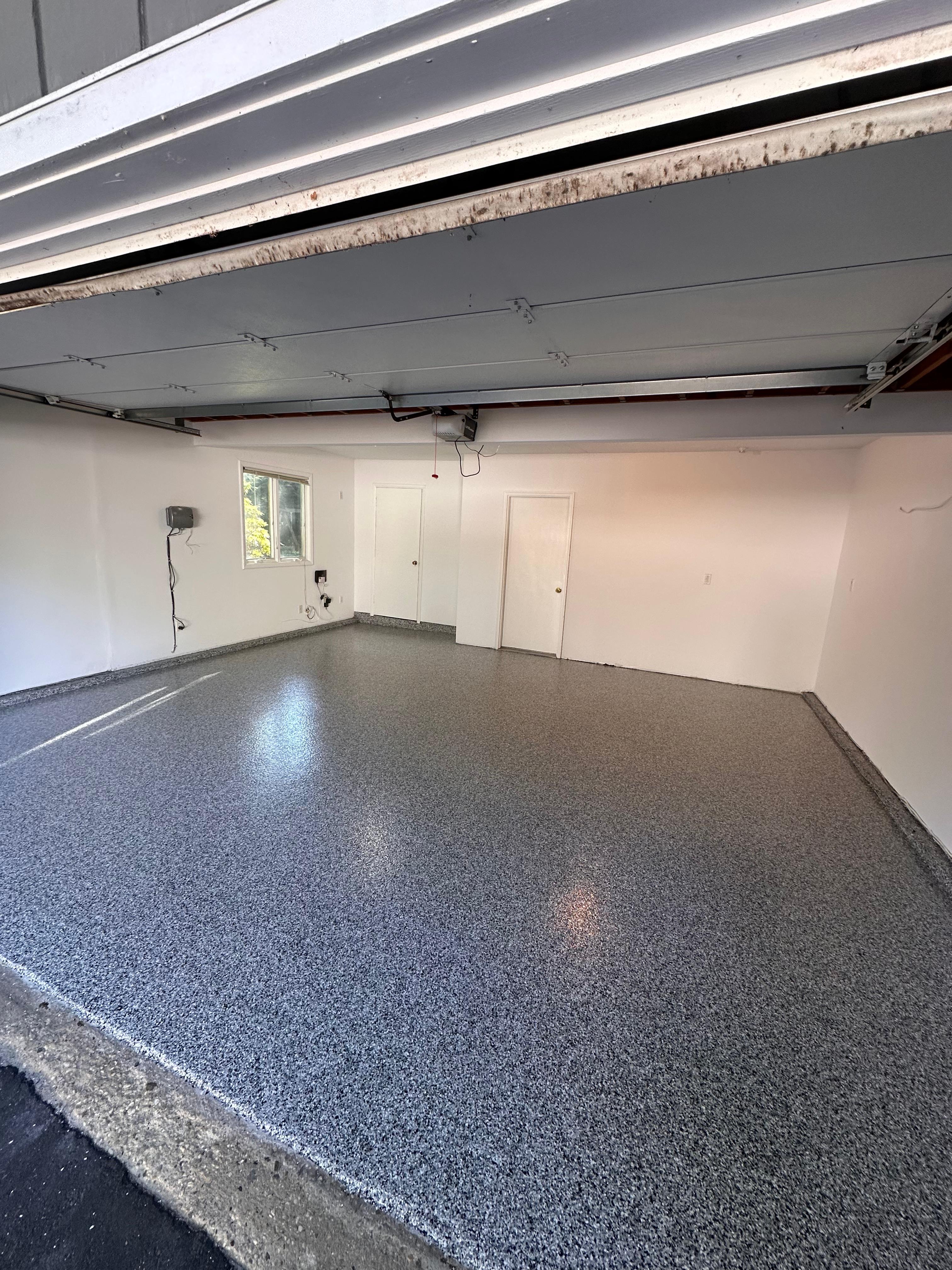 Garage with speckled epoxy flake floor coating by Mozy Construction