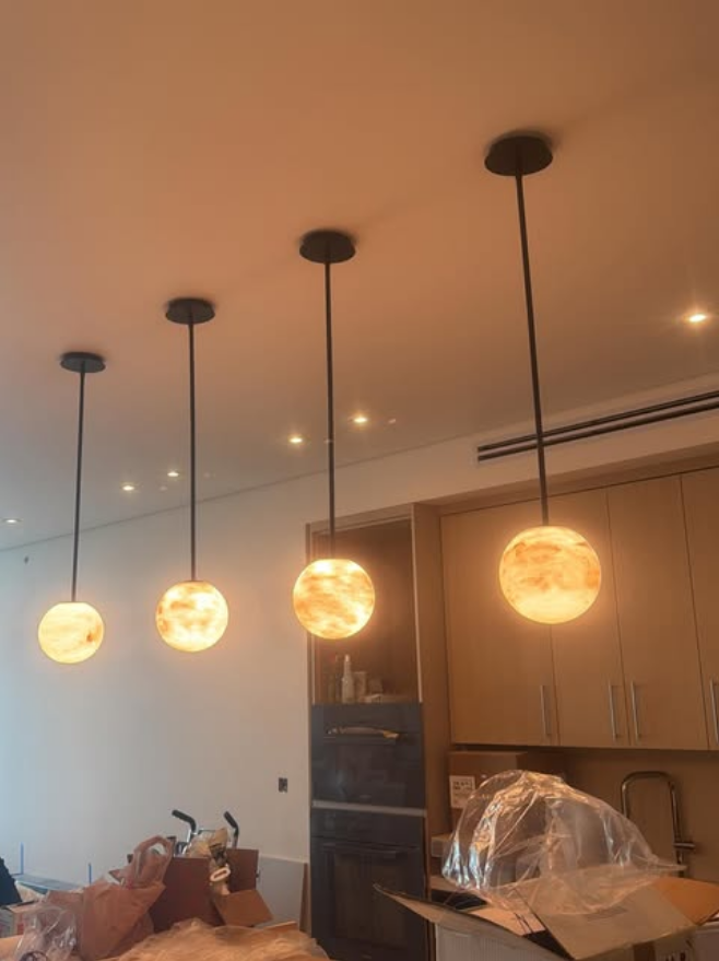 Kitchen with alabaster pendant lighting by Mozy Construction